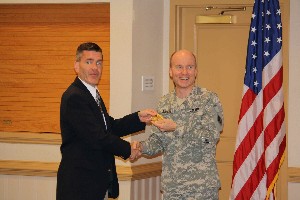 Paul Reimers (l), chapter president, presents Col. Barlow with a chapter coin following the colonel's speech at the August luncheon.